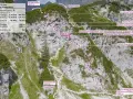 Trasa via ferrata Austria: Klamml Klettersteig w Wilder Kaiser. Widok z góry na skalną ścianę z oznaczeniami trudności i trasą.