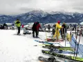 Ludzie na nartach i snowboardach na stoku, w tle góry. Zastanawiasz się, ile się idzie na Gubałówkę? Tu jest zimowo i aktywnie!