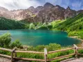 Turkusowe jezioro otoczone zielonymi zboczami gór i lasem, przypominające beskidzkie Morskie Oko.