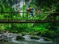 Rowerzysta wykonuje trik na drewnianym moście nad potokiem. Wspaniałe trasy rowerowe Zakopane czekają na odkrycie!