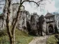 Ojcowski Park Narodowy atrakcje: ruiny zamku na skale, kamienna wieża bramna i ścieżka wśród zieleni.