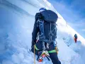 Wspinaczka na szczyt w Himalajach. Dwóch alpinistów wspinających się po lodowej ścianie, wspinaczka na szczyt w Himalajach.