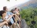 Grupa młodych ludzi na szlaku, podziwiająca widok. Idealne miejsce na pierwsze wyprawy trekkingowe dla początkujących.