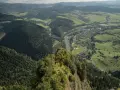 Widok z Trzech Koron na Szczawnicę i Dunajec. Góry Pieniny w zieleni, malownicza dolina rzeki i miasteczko.