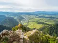Widok z góry na dolinę z rzeką i miasteczkiem, w oddali majaczą Tatry. Widok przypomina trzy korony.