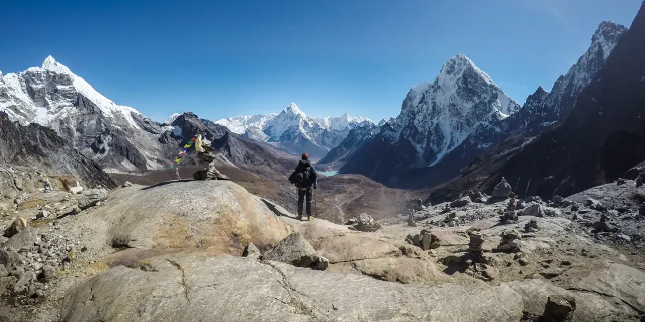 Trekking w Himalajach. Samotny turysta podziwia majestatyczne szczyty i doliny.