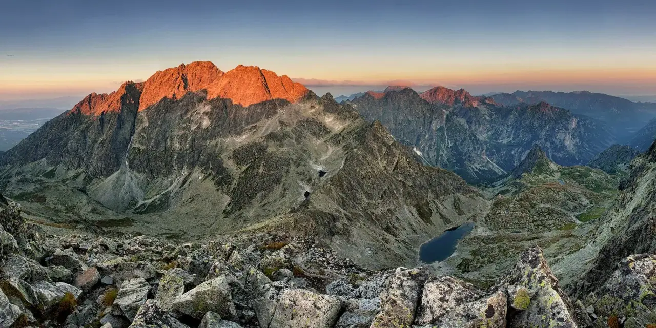 Zachód słońca nad Tatrami. Widok z polski na oświetlone zbocza Gerlacha, skaliste szczyty i górskie jeziora.