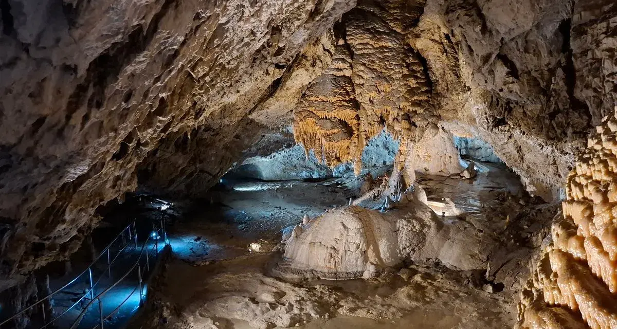 Wnętrze jaskiń w Zakopanem, z naciekami, stalaktytami i stalagmitami, oświetlone niebieskim światłem.