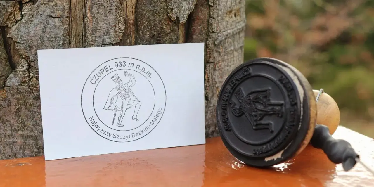 Stempel i kartka z napisem "Czupelek 933 m n.p.m. Najwyższy szczyt Beskidu Małego" - pamiątka z górskiej wyprawy.
