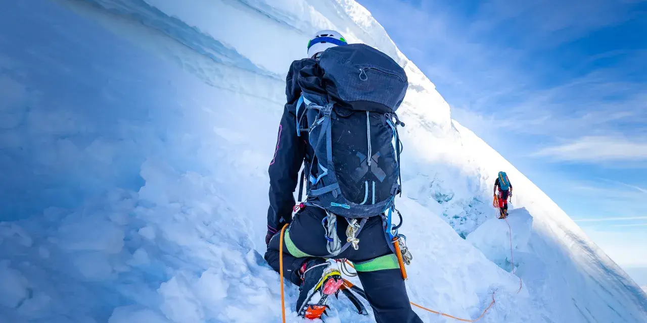 Wspinaczka na szczyt w Himalajach. Dwóch alpinistów wspinających się po lodowej ścianie, wspinaczka na szczyt w Himalajach.