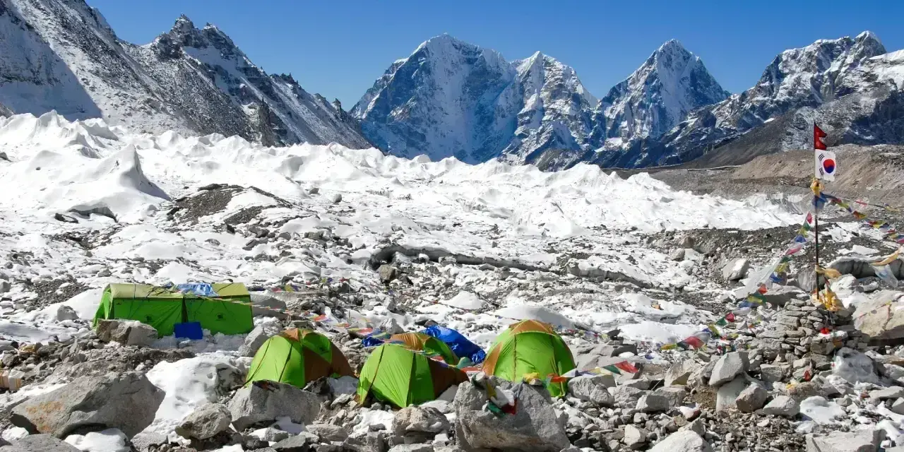 Namiotowe miasteczko na lodowcu, część trasy na Mount Everest. W tle ośnieżone szczyty.
