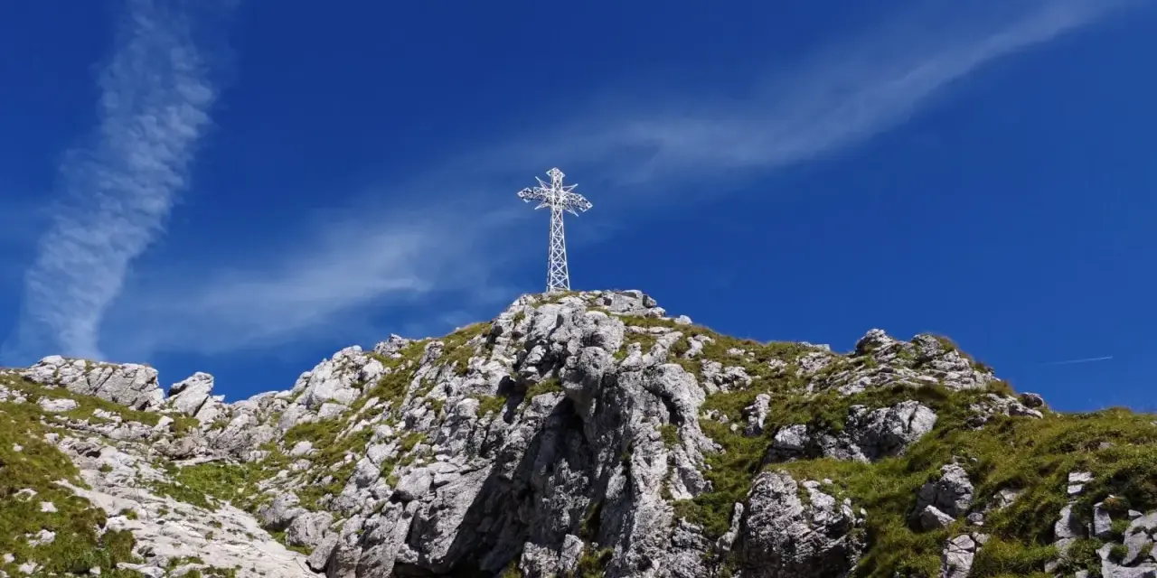 Biały krzyż na skalistym szczycie, symbol Tatr. Zastanawiasz się, ile ma Giewont?