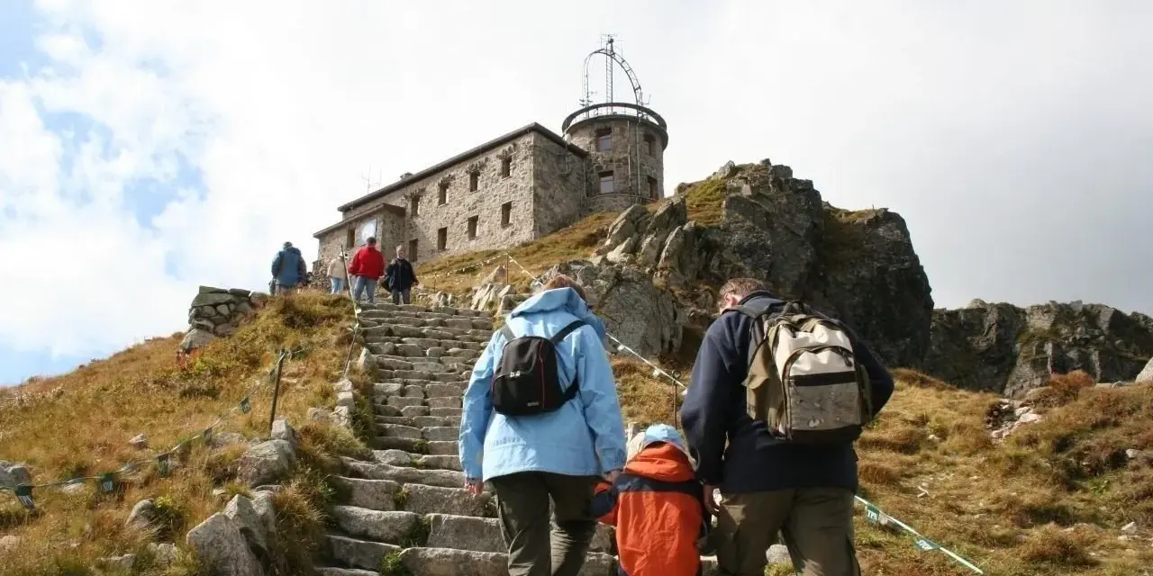 Rodzina wspina się kamiennymi schodami na Kasprowy Wierch. Trasa prowadzi do obserwatorium meteorologicznego.