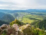 Widok z góry na dolinę z rzeką i miasteczkiem, w oddali majaczą Tatry. Widok przypomina trzy korony.