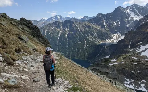 Turystka na szlaku w Tatrach, podziwia widok na jeziora i skaliste szczyty. Szpiglasowy Wierch trudność szlaku jest wyzwaniem, ale widoki wynagradzają wysiłek.