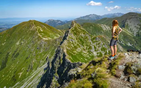 Widok na zielone szczyty Tatr Zachodnich na Słowacji. Kobieta podziwia panoramę gór.