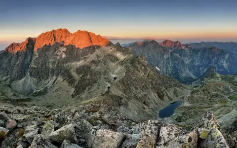 Zachód słońca nad Tatrami. Widok z polski na oświetlone zbocza Gerlacha, skaliste szczyty i górskie jeziora.