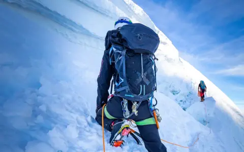 Wspinaczka na szczyt w Himalajach. Dwóch alpinistów wspinających się po lodowej ścianie, wspinaczka na szczyt w Himalajach.