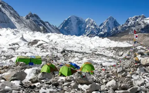 Namiotowe miasteczko na lodowcu, część trasy na Mount Everest. W tle ośnieżone szczyty.