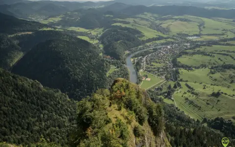 Widok z Trzech Koron na Szczawnicę i Dunajec. Góry Pieniny w zieleni, malownicza dolina rzeki i miasteczko.