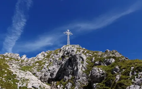 Biały krzyż na skalistym szczycie, symbol Tatr. Zastanawiasz się, ile ma Giewont?