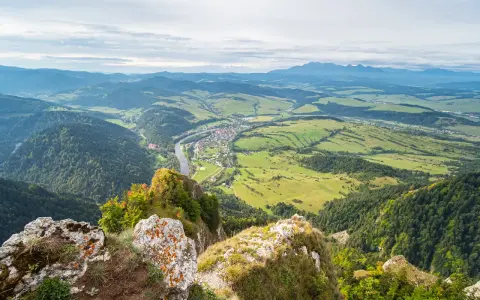 Widok z góry na dolinę z rzeką i miasteczkiem, w oddali majaczą Tatry. Widok przypomina trzy korony.