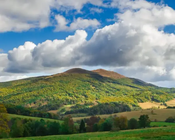 Bieszczady jakie to góry? Łagodne, zielone wzgórza pokryte lasami, z pojedynczymi szczytami i malowniczymi dolinami, pod błękitnym niebem z kłębiastymi chmurami.