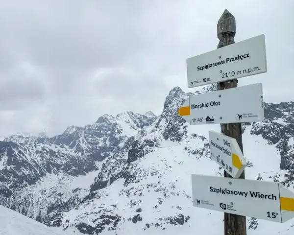 Szpiglasowy Wierch od Morskiego Oka. Znak szlaku w zimowych Tatrach wskazuje drogę na szczyt.