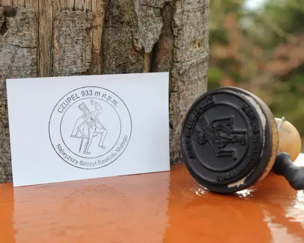 Stempel i kartka z napisem "Czupelek 933 m n.p.m. Najwyższy szczyt Beskidu Małego" - pamiątka z górskiej wyprawy.