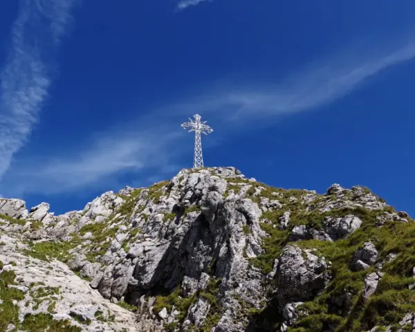 Biały krzyż na skalistym szczycie, symbol Tatr. Zastanawiasz się, ile ma Giewont?