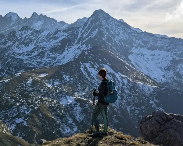 Osoba z plecakiem i kijkami podziwia zimowe Tatry Bielskie. Wspaniałe widoki na szlaki.