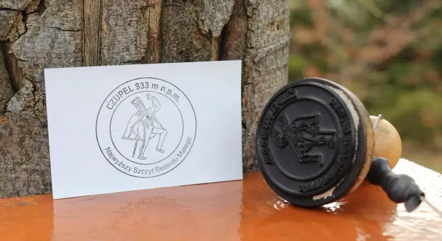 Stempel i kartka z napisem "Czupelek 933 m n.p.m. Najwyższy szczyt Beskidu Małego" - pamiątka z górskiej wyprawy.