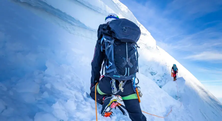 Wspinaczka na szczyt w Himalajach. Dwóch alpinistów wspinających się po lodowej ścianie, wspinaczka na szczyt w Himalajach.