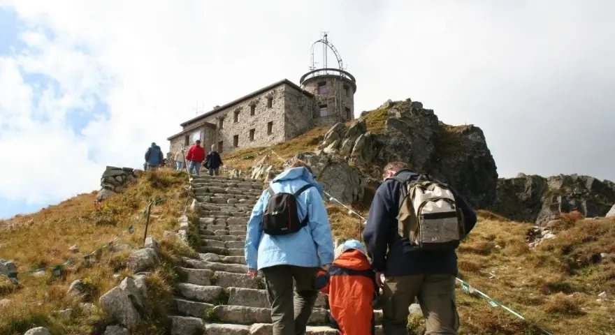 Rodzina wspina się kamiennymi schodami na Kasprowy Wierch. Trasa prowadzi do obserwatorium meteorologicznego.