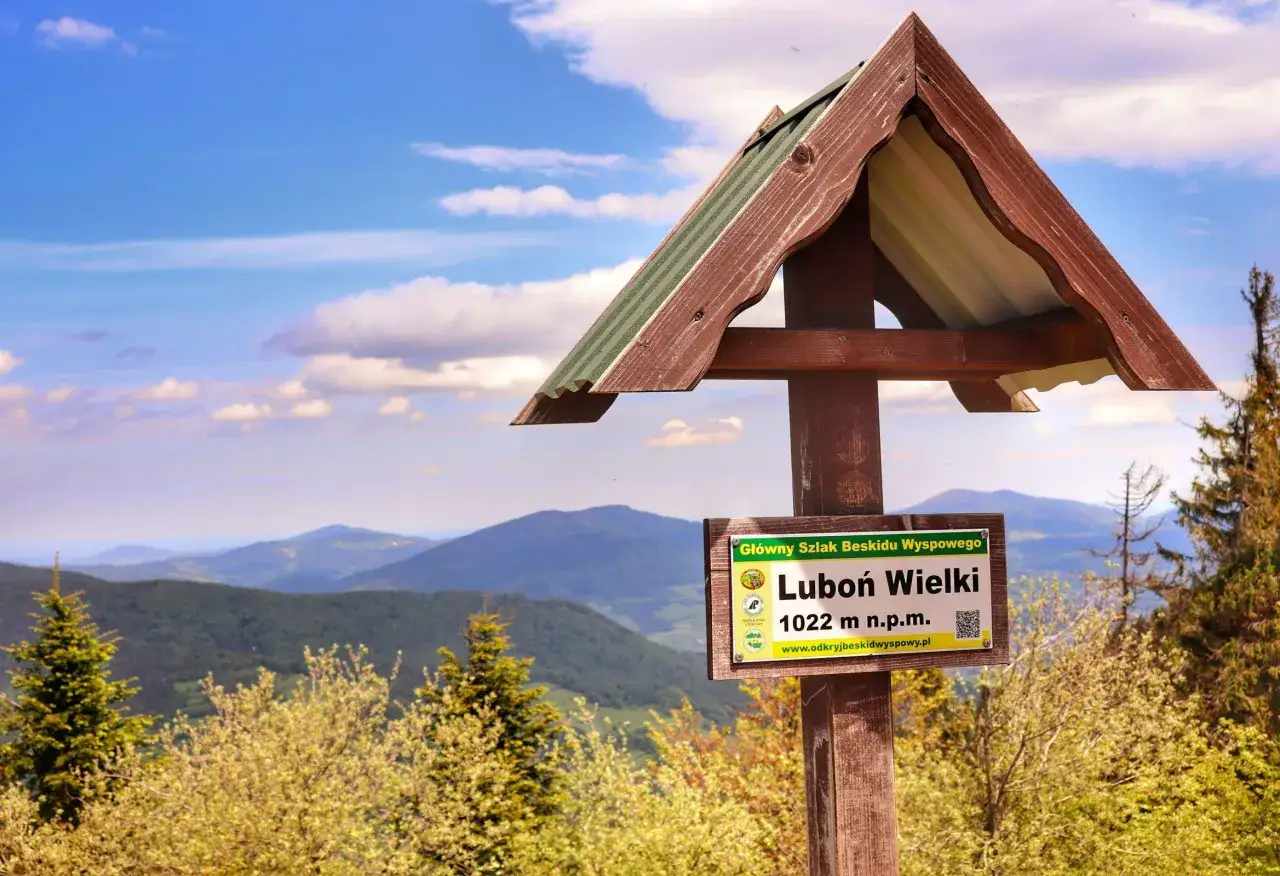 Tablica informacyjna na szczycie Luboń Wielki (1022 m n.p.m.) w Beskidzie Wyspowym. Piękny widok na góry i chmury. Idealne miejsce na piesze beskid wyspowy trasy.