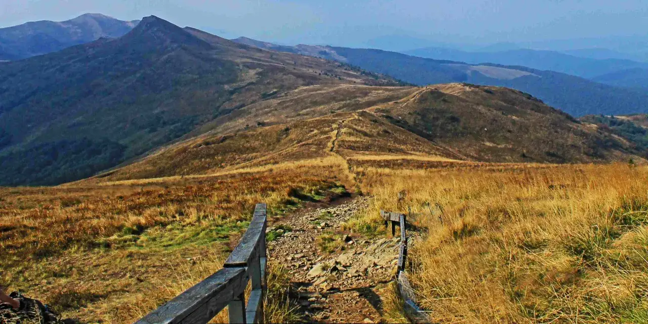 Bieszczady jakie to g&oacute;ry? Rozległe połoniny, kamieniste ścieżki i łagodne szczyty w oddali.