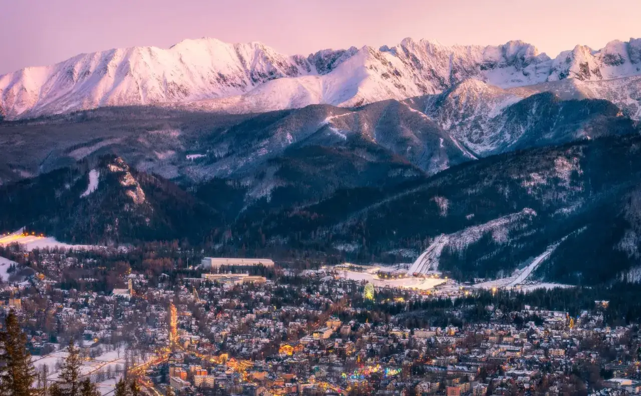 Ośnieżone Tatry nad rozświetlonymi światłami Zakopanego. Idealne miejsce na plan 
