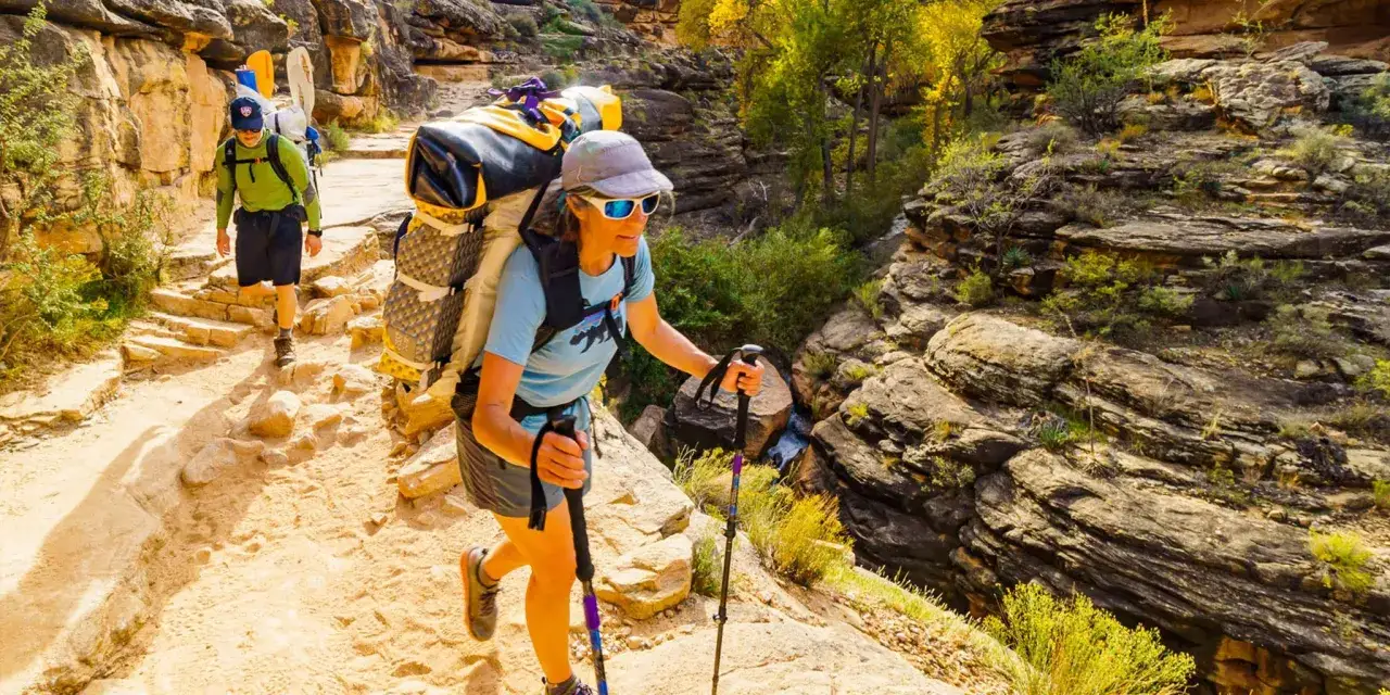 Ludzie z plecakami idą szlakiem w kanionie. To jest właśnie hiking – aktywność na świeżym powietrzu.