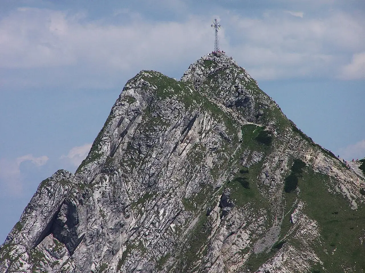 Szczyt Giewontu z krzyżem i turystami. Warto wiedzieć, ile ma Giewont, by docenić ten widok.