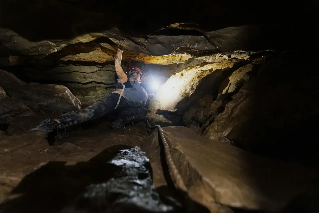 Odkrywanie jaskini to fascynująca przygoda. Speleologia co to? To badanie jaskiń, często w trudnych warunkach, jak na tym zdjęciu.