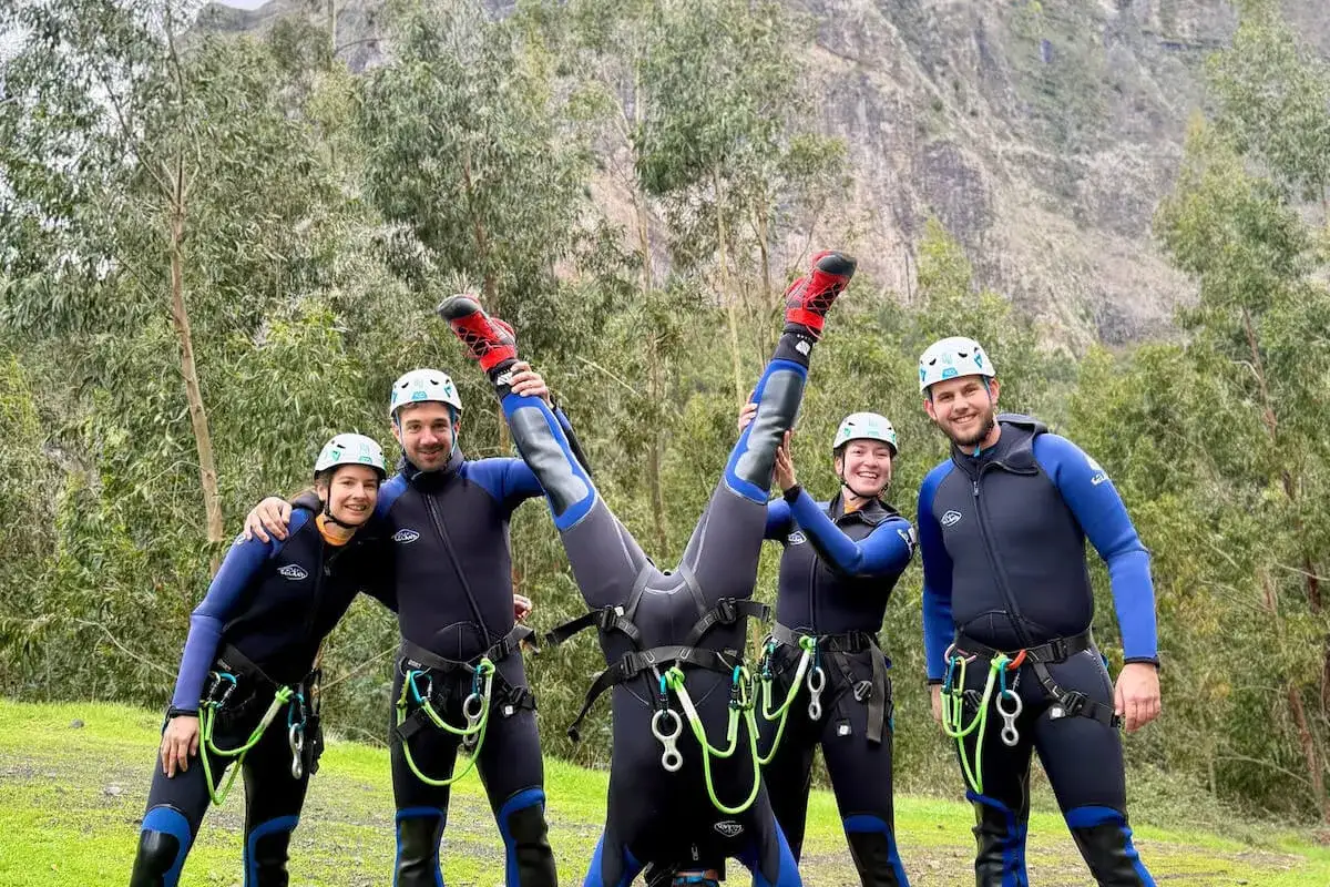 Pięć osób w piankach i kaskach, gotowych na przygodę. Jedna osoba robi stanie na rękach. To właśnie canyoning co to za sport!